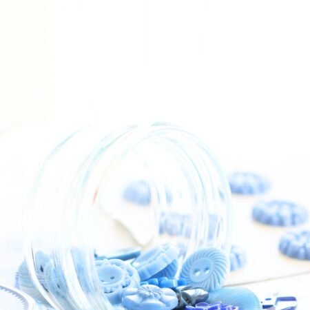 Vintage blue buttons spilling out of a jar