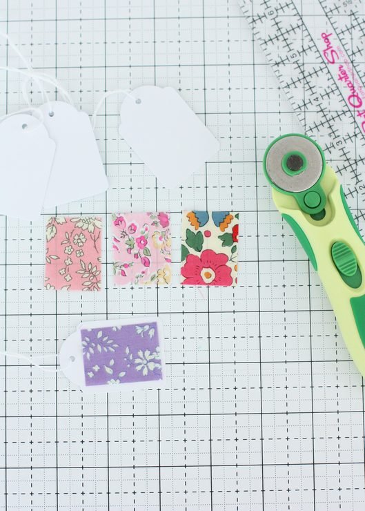 small pieces of Liberty fabric, card tags, ruler and rotary cutter.