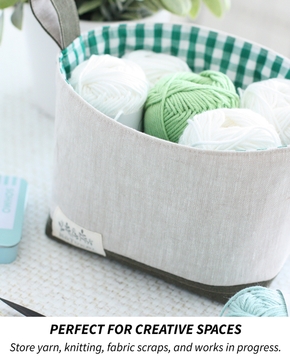 Fabric storage bucket filled with cream and green yarn, sewn in Hasting Street Linen and styled for knitting and crochet storage.