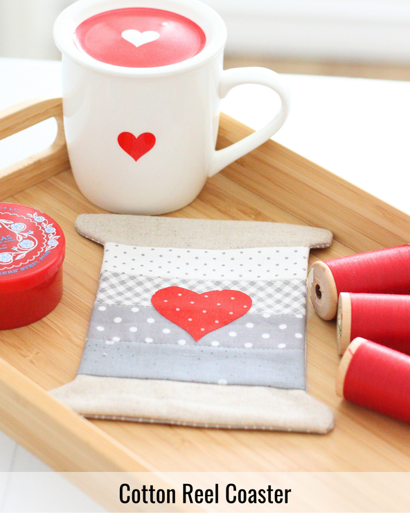 Cotton reel shaped quilted coaster featuring colorful patchwork fabric inspired by classic sewing thread spools.